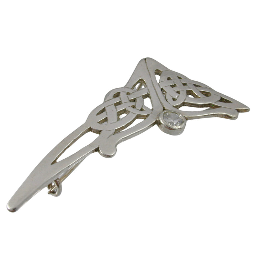 Triangular shaped brooch with open work celtic designs, a round manmade diamond is on the right at the bottom of the upper part. There is a safety catch on the sterling silver rooch.